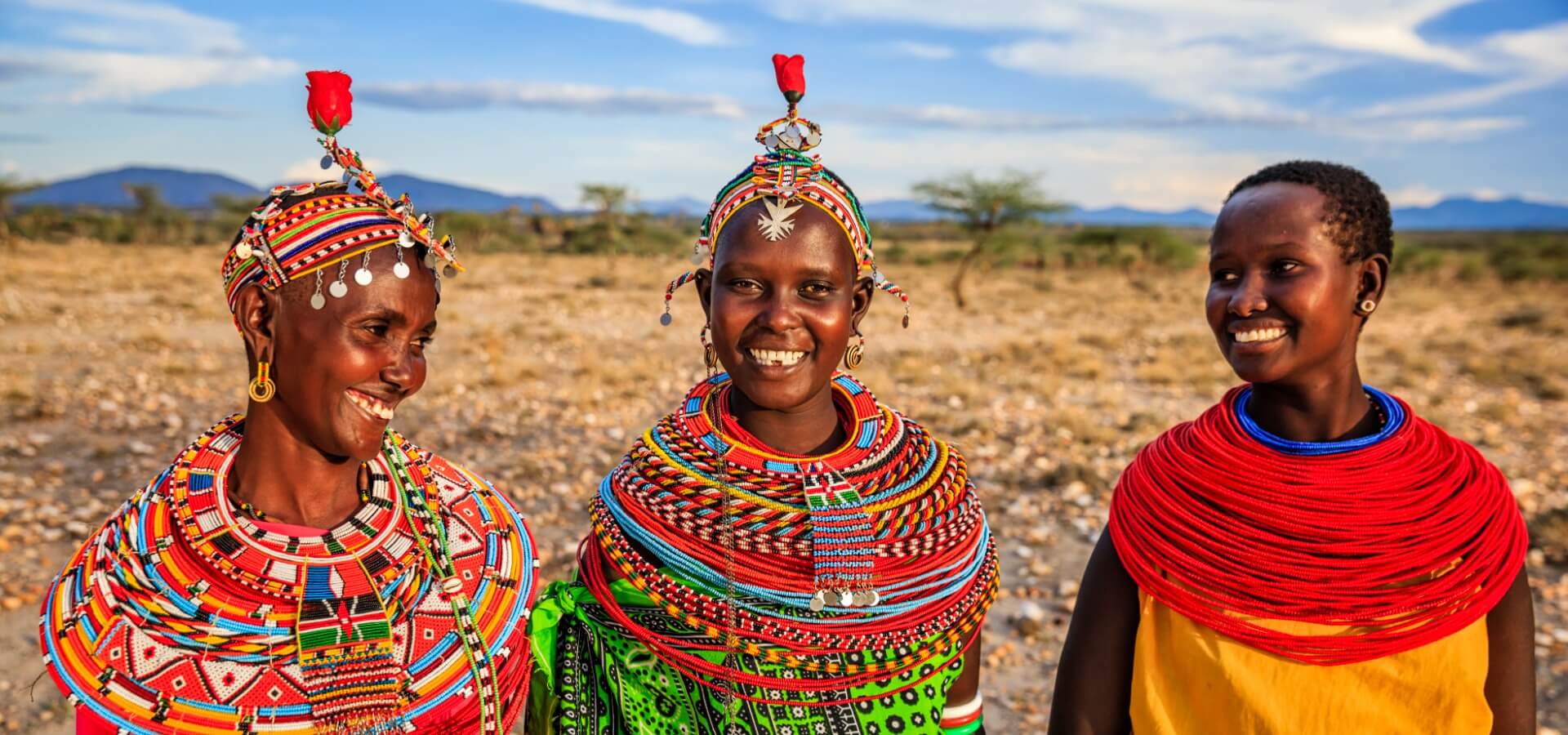 Tres mujeres indígenas afrodescendientes de Kenya vistiendo ropa tradicional.