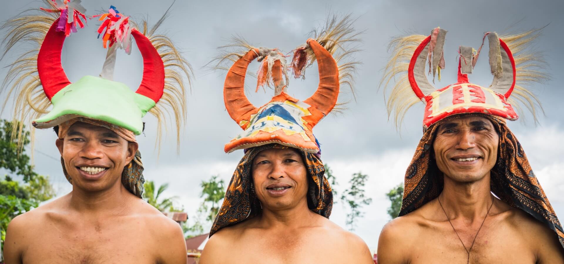 Três homens indígenas da Indonésia vestindo roupa tradicional