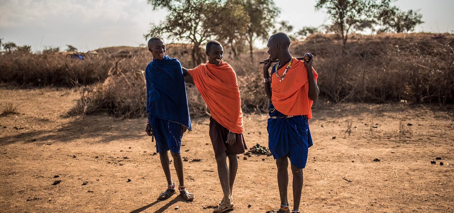 Grupo de homens afrodescendentes posando na savana africana.