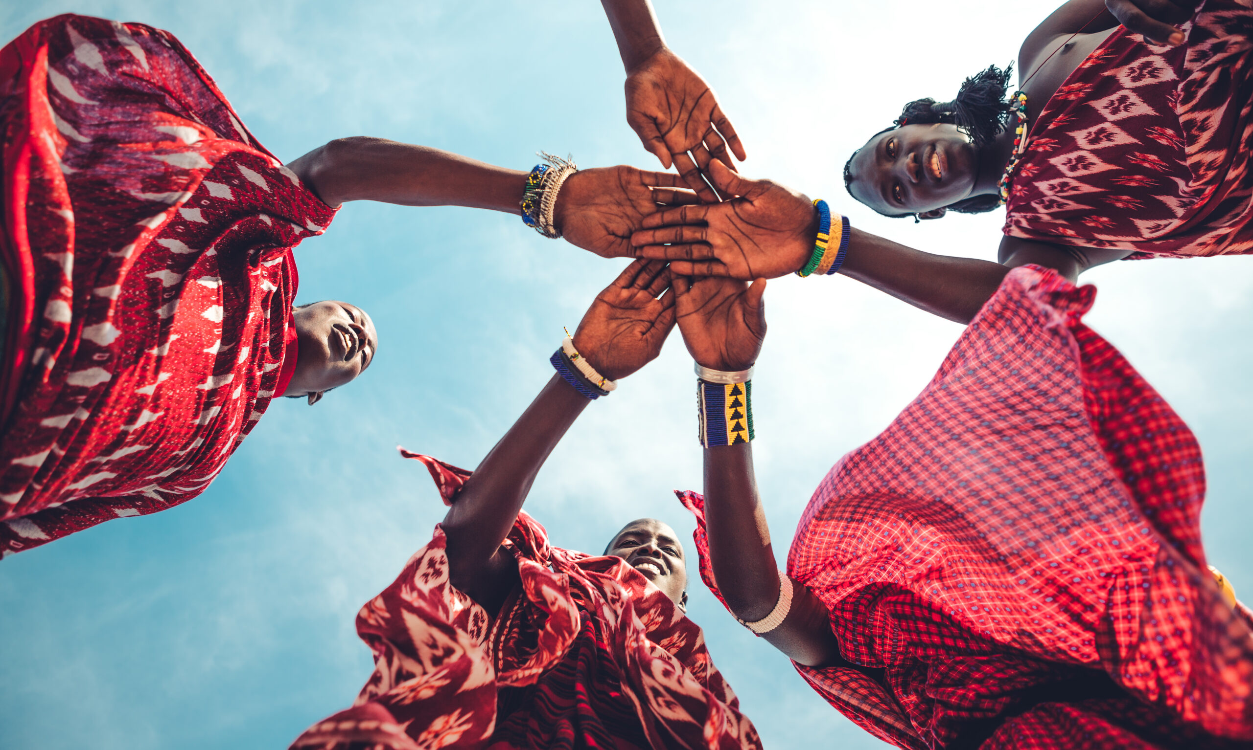 Masai in traditional clothes joining hands in unity (Zanzibar, Tanzania). 